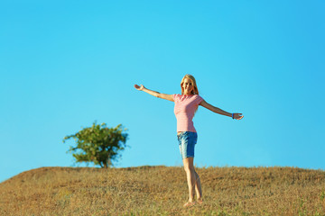 Fototapeta premium Happy young woman on blue sky background