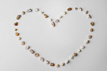 Heart made of small pebbles, isolated on white