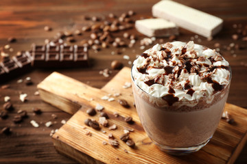 Delicious milkshake with chocolate syrup and coffee on wooden background