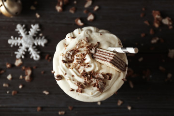 Delicious milkshake with Christmas decoration on wooden background