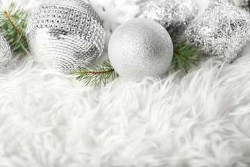 Fototapeta na wymiar Close up view of beautiful Christmas baubles and coniferous branches on white fur