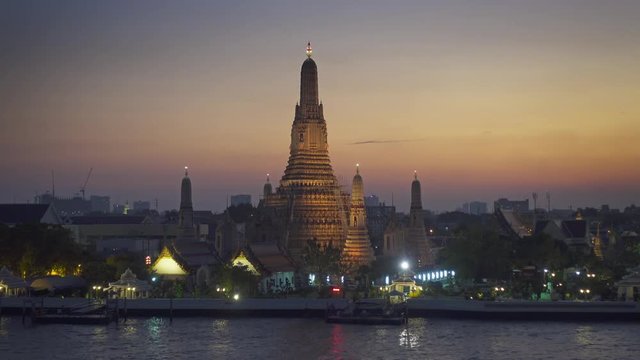 Landscape with Wat Arun at twilight time. Buddhist temple located along the Chao Phraya river in Bangkok, Thailand  4k
