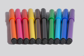 10 multi-coloured felt-tip pens on a white background