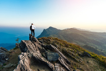 businessman success hiking on the peak of rocks mountain at suns