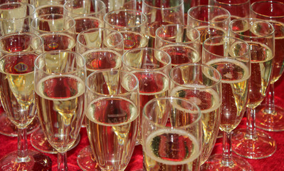 Glass wine glasses with champagne on a red tablecloth