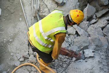 A construction workers cutting foundation pile using hacking method at the construction site. He using the heavy duty mobile hacker machine.  
