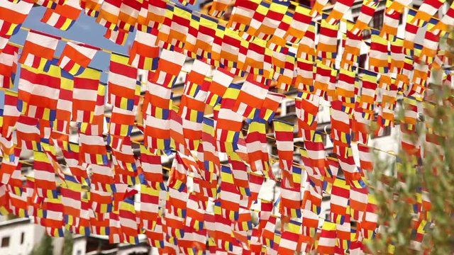 A lot of Buddhist flags waving on the wind with blue sea background in Thikse Monastery, India