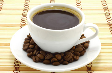 Coffee cup with coffee beans on a wooden background