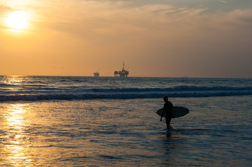 silhouette of Surfer at sunset on Huntington beach, southern California