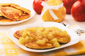 Pancakes with apple jam on white plate.