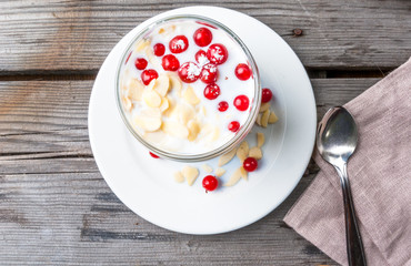 Light and healthy breakfast: oatmeal with yogurt, almonds and berries. Top view, copy space
