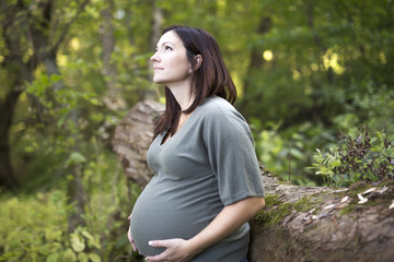 Beautiful pregnant woman relaxing on a park