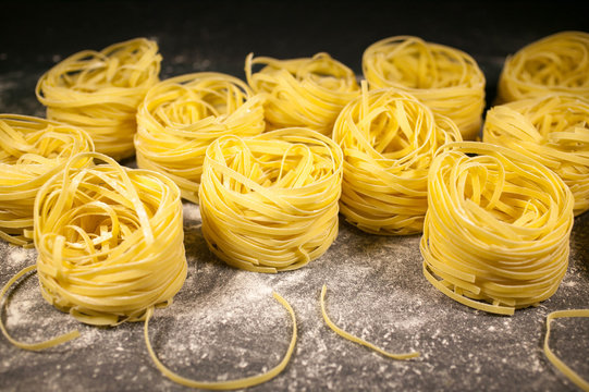 Raw pasta on a table. Italian paste a dark background. Selective focus. Mediterranean kitchen