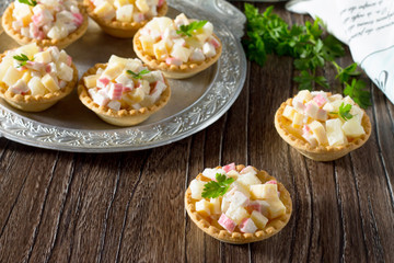 Holiday appetizer: tartlets with crab sticks, cheese and pineapp