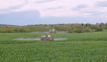 Fototapeta premium two tractors spraying