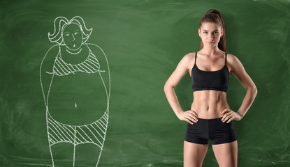 Sporty girl with slim body and drawing of woman on chalkboard