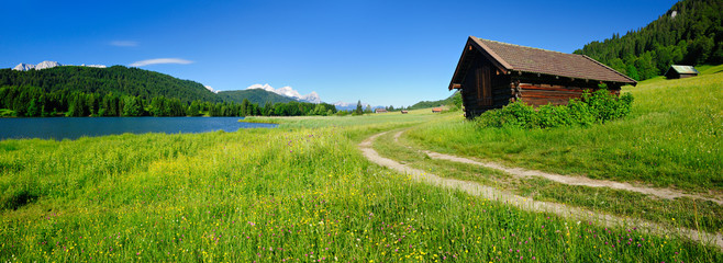 Sommerlandschaft in den bayerischen Alpen, hinten ein Bergsee und das Wettersteingebirge mit der...