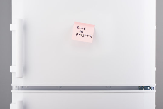 Diet in progress note on pink sticky paper on refrigerator