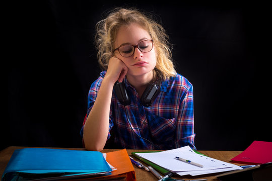une adolescente blonde devant son travail avec une expression d&eacute;pit&eacute;e