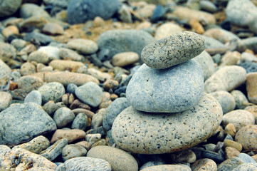 Background from sea stones for design. Pyramid from sea stones. Sea stones