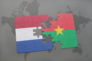 puzzle with the national flag of netherlands and burkina faso on a world map background.