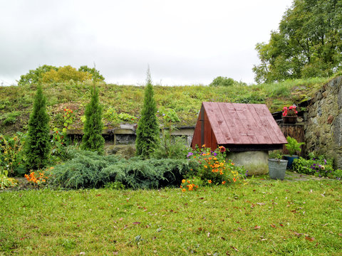 traditional old water well with wooden roof in an autumn country garden