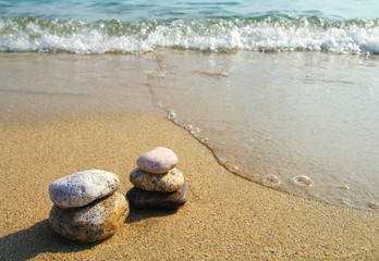 Fototapeta na wymiar Pyramid from sea stones against the sea. Sea stones