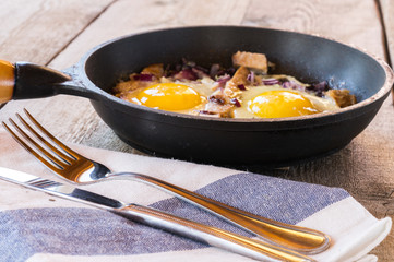 Scrambled eggs with bacon and onions, pan-fried, for Breakfast.