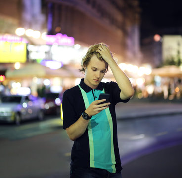 Teenage boy typing text message.Using smart phone.Dusk.Selektive focus
