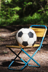 Old soccer ball on a chair.