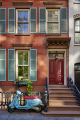 a brownstone building with a scooter