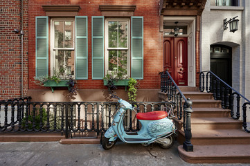 a brownstone building with a scooter