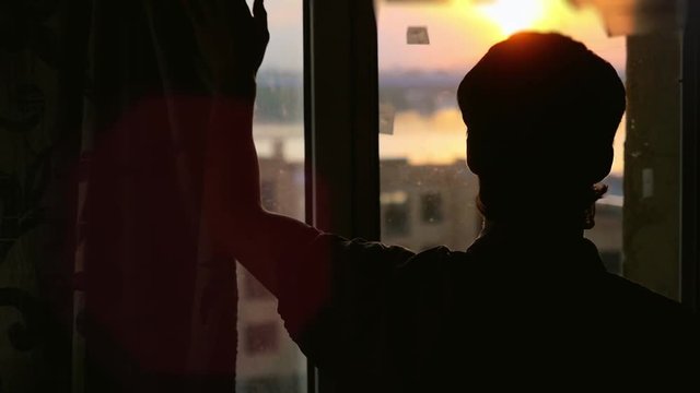 Man in dark room opens curtains on window to the sun and try to touch the sunshine in slowmotion. 1920x1080