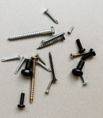 Scattered on a gray background of different screws.