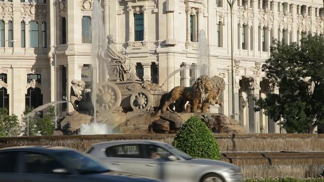 Plaza de Cibeles with traffic. It's a square with a neo-classical complex of marble sculptures with fountains that has become an iconic symbol for the city of Madrid.