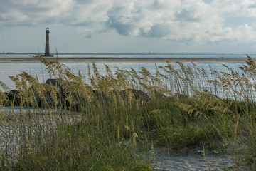 Beach destination.  Lighthouse in the morning.  Sea Oats blowing in the ocean breeze.  