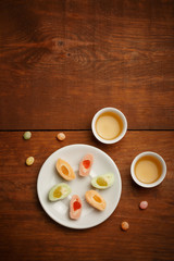Fototapeta na wymiar Delicious mochi rice cakes on white plate, porcelain cups with g
