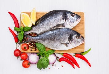 Fresh raw dorado fish on wooden cutting board. Top view, copy space