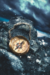 compass on rocks with a dark sky © fergregory