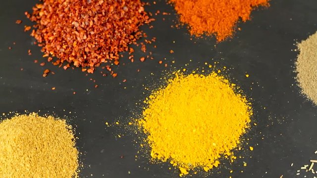 Various spices on rotating black stone surface. 1920x1080p HD video