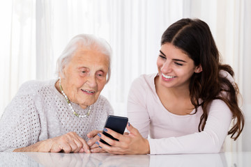 Two Women Using Smartphone At Home