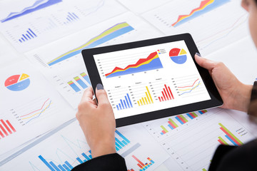 Businesswoman Analyzing Financial Graphs Using Digital Tablet