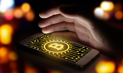 Cyptocurrency or digital money concept image.Bitcoin sign and electrical circuit icon on smartphone...