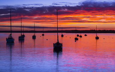 The Sun sets over Poole Harbour in Dorset at Hamworthy pier jett