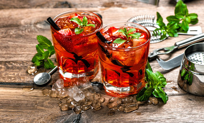 Red drink with ice. Aperitif. Cocktail making bar tools