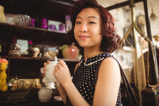 Portrait of stylish woman selecting a tea pot