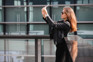 Fototapeta premium Young beautiful woman taking a selfie in the city