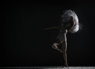 Obraz na płótnie Canvas Strange dance with dust performed by graceful girl