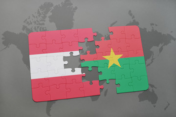 puzzle with the national flag of austria and burkina faso on a world map background.