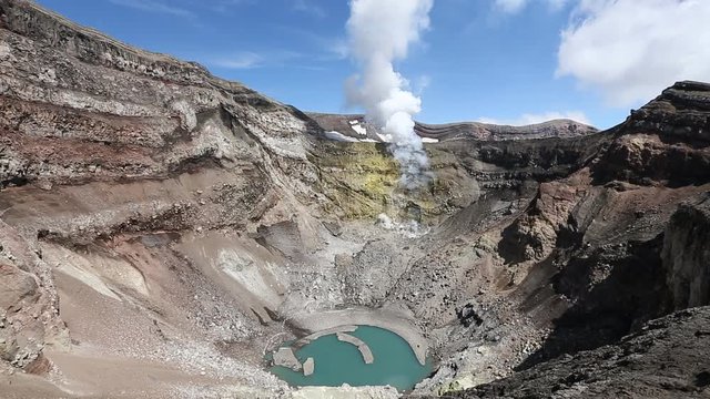 Volcanic landscape of Kamchatka: view of crater active Gorely Volcano, crater lake and fumarolic activity of volcano - active fumaroles, emissions steam and gas. Russia, Far East, Kamchatka Peninsula.